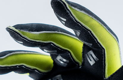 Close-up of black protective gloves with bright lime-green interior lining.