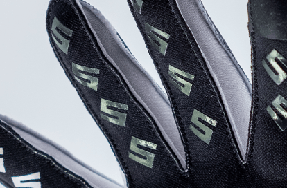 Close-up of black fabric straps with a repeating light-green S logo pattern.