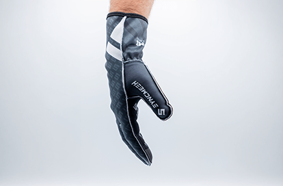 Black goalkeeper glove with white branding, suspended in mid-air in a clean studio backdrop, showcasing padding and design.